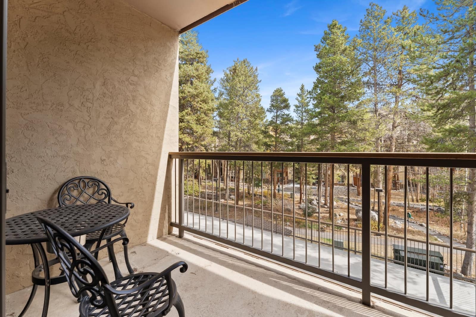 The private deck with bistro furniture and a pine forest view