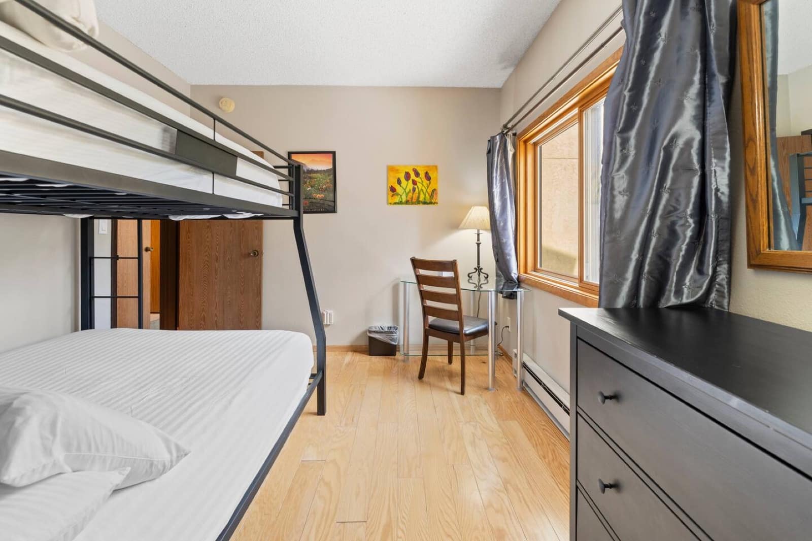 Guest bedroom with queen-over-queen bunk, desk, and dresser