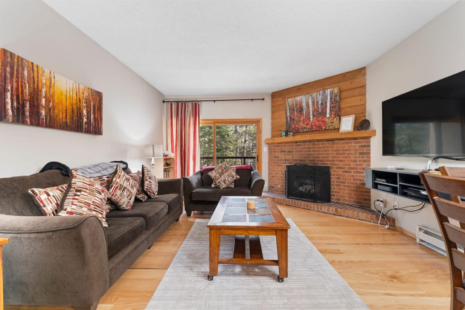 The living room of 204 — brick fireplace, wood mantle, two sofas